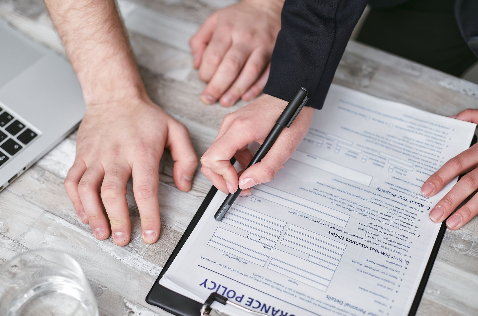 Close detail view of client signing official documentation with advisor